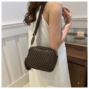 Model wearing vintage crossbody camera bag with wide strap and small round coin purse