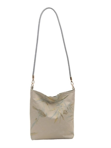 Embroidered canvas shoulder bag with golden bird and blue leaf pattern on white background