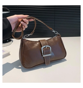 Dettaglio della borsa sottobraccio in pelle marrone scuro con cuciture bianche e fibbia