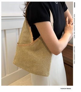 Détail du sac à bandoulière en paille tressée avec bordure en similicuir brun et motif ajouré