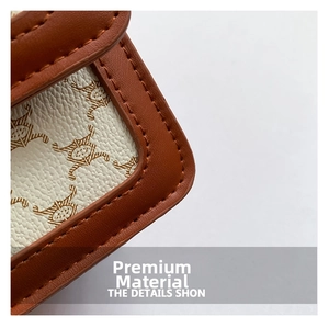Detail of vintage canvas bag with brown logo pattern and leather trim stitching