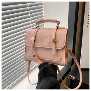 Détail d'un sac à main en similicuir rose avec texture plissée et anneaux dorés