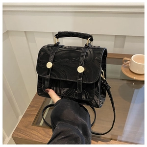 Détail d'un sac à main argenté texture marbre avec boucles dorées et bandoulière fine