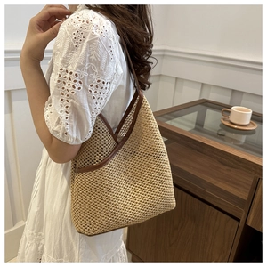 Detail of handmade woven bucket bag with brown leather trim and shoulder strap