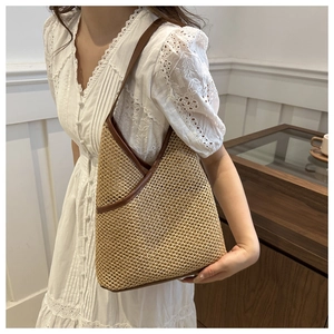 Detail of hand-woven straw shoulder bag with contrast leather trim and large capacity