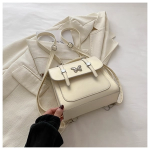 Detailed view of cream leather backpack with silver butterfly buckle and adjustable straps