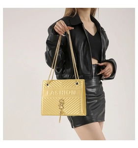 Detail of golden quilted crossbody bag with metal chain strap and fashion embossing