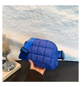 Détail du sac banane bleu matelassé avec coutures à carreaux et sangle réglable