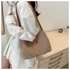 Detail of khaki suede checkered tote bag with brown leather straps and fashion label