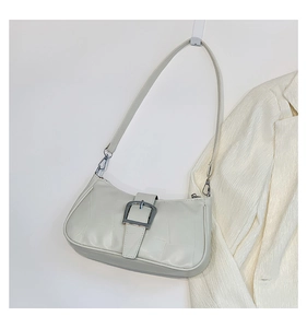 Dettaglio borsa a spalla beige in pelle con cuciture a quadri e fibbia in metallo argento