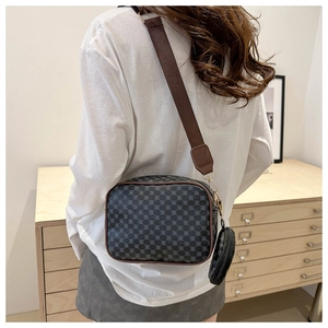 Detail of grey vintage patterned crossbody bag with wide strap and coin purse charm