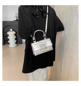 Silver crocodile embossed mini handbag with chain strap shown on model for outfit styling