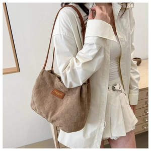 Detail of checkered shoulder bag with suede texture and brown leather straps