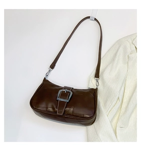 Dettaglio borsa baguette vintage marrone con cuciture bianche e fibbia in argento