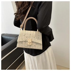 Detail of floral straw handbag featuring lace trim, round handle and gold twist-lock closure