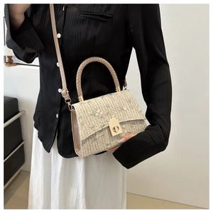 Detail of beige woven crossbody bag with floral embroidery and gold metal twist lock