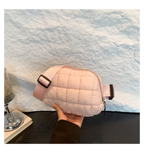 Détail d'un sac bandoulière matelassé rose avec sangle et boucle en plastique