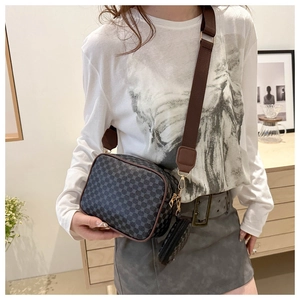 Detail of trendy crossbody camera bag with geometric pattern and wide brown strap