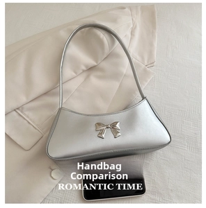 Silver PU leather underarm bag with a metal bow detail shown next to a smartphone