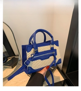 Détail du petit sac bandoulière en cuir bleu et tissu tissé avec fermeture éclair décorative