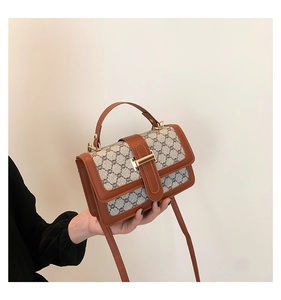 Détail du sac vintage carré avec bordure en cuir marron et fermoir en métal doré