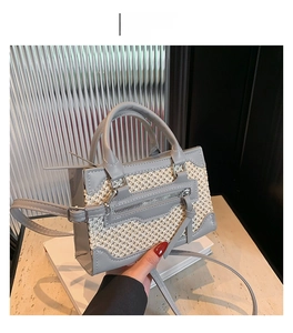 Détail de la texture en cuir gris et tissu tissé sur un sac à main bandoulière chic