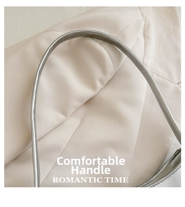 Detail of the rounded grey handle on a minimalist shoulder bag with smooth texture