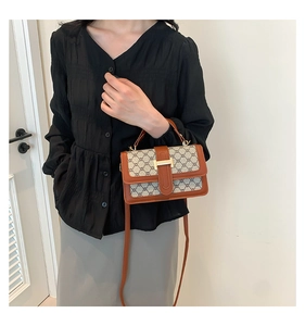 Vue détaillée du sac à bandoulière vintage monogrammé avec fermoir en métal doré