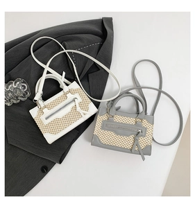 Détail du mini sac carré en paille tressée et cuir avec fermeture éclair et poignée haute