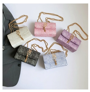 Détail de cinq sacs bandoulière pastel avec texture tissée et pompons dorés