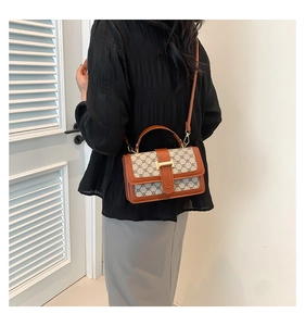 Detail shot of vintage beige monogram canvas bag with brown leather trim and golden H buckle
