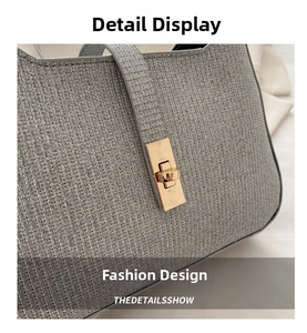 Détail de la texture tissée argentée du sac à main avec boucle métallique dorée