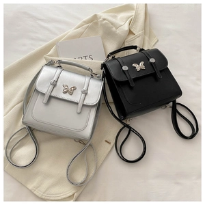 Close-up of black and silver butterfly accent handbags with metal buckles on fabric