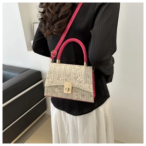 Detail of straw woven handbag with floral embroidery and pink handle for summer
