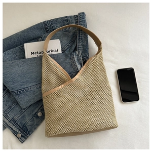 Détail du sac cabas en paille tissée avec lanières en cuir et design en forme de V