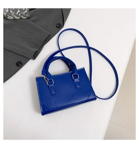 Détail du mini sac carré en cuir bleu Klein avec ferrures argentées et bandoulière