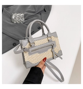 Détail du sac bandoulière en cuir gris et paille beige avec gland décoratif long