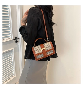 Détail du sac à bandoulière en toile imprimée rétro avec garniture en cuir brun et fermoir doré