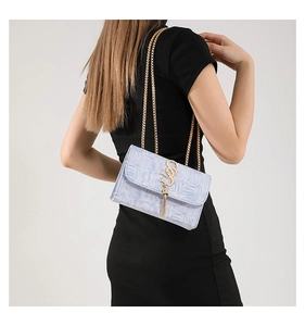 Détail du sac à chaîne bleu clair avec texture nuage, fermoir S doré et pompon métal