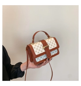Gros plan détaillé sur les garnitures en cuir marron et le motif monogramme du sac à main