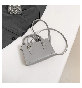 Vue détaillée d'un sac à main gris moderne en cuir avec finition lisse et poignée élégante