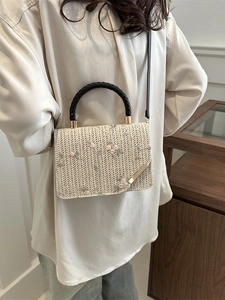 Chic woven straw square bag with floral embroidery and round handles in a rustic style