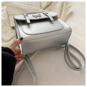Macro shot of silver metallic PU backpack with adjustable straps and fine stitching details