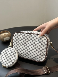 Retro pattern crossbody bag with wide strap and round coin purse on a desk
