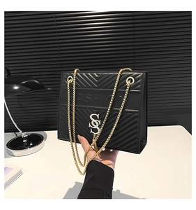 Detail of black V-quilted texture with gold chain straps and FASHION embossed logo