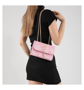 Détail du sac bandoulière rose gaufré croco avec chaîne dorée et pompon logo GS