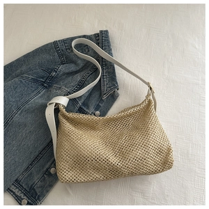 Détail du sac fourre-tout tissé beige avec bandoulière en cuir blanc et boucle métal