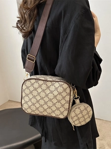 Retro crossbody bag with clover print and wide shoulder strap shown on model back