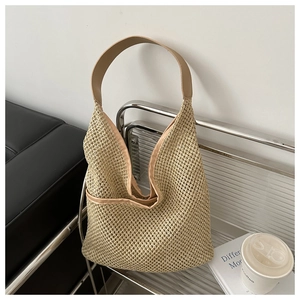 Détail du tissage et de la bandoulière en cuir kaki lisse sur le sac hobo beige