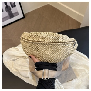 Detail of hand-woven mini straw waist bag featuring silver zipper and adjustable strap
